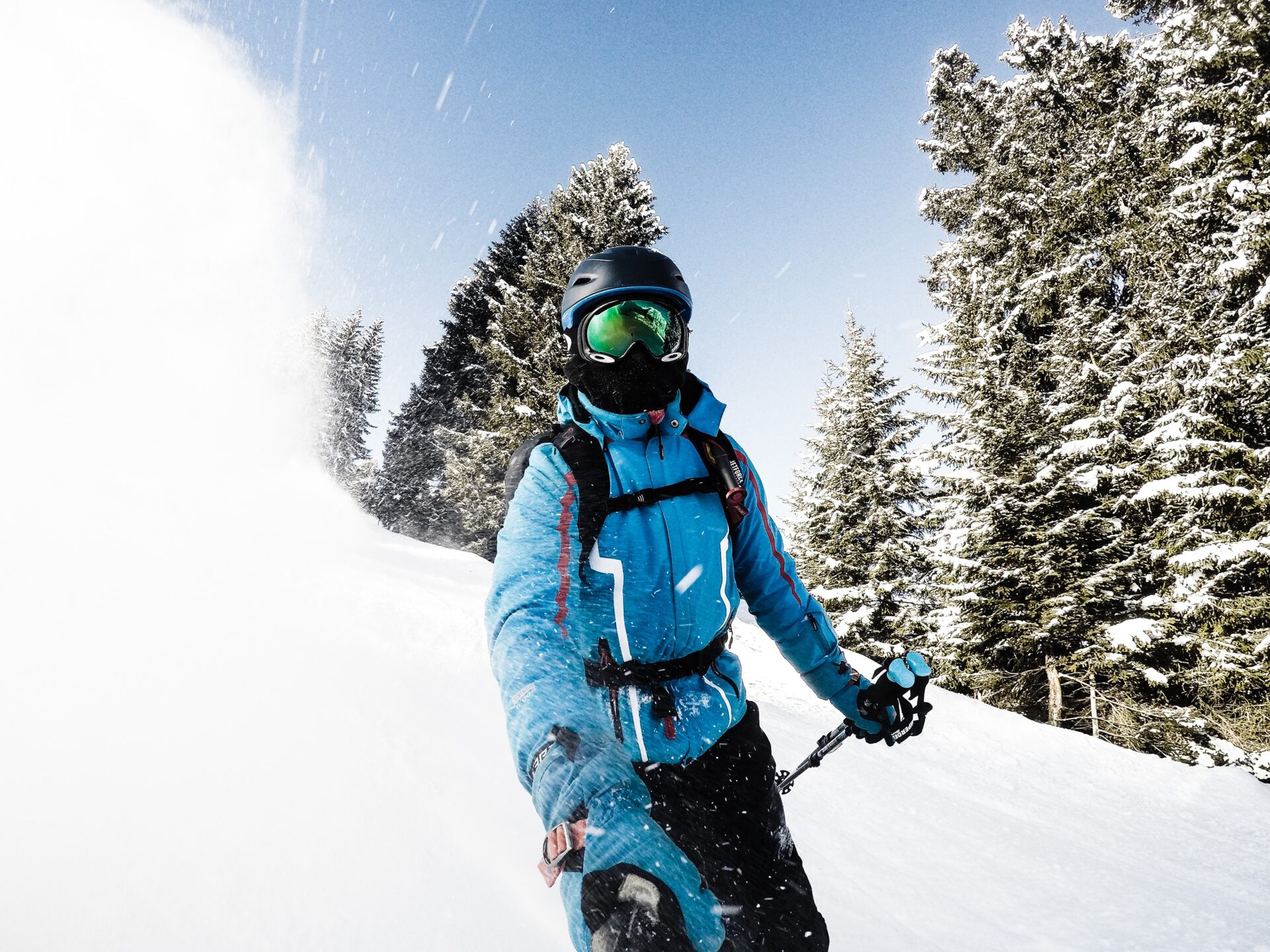 skier in a blue jacket and oakley googles